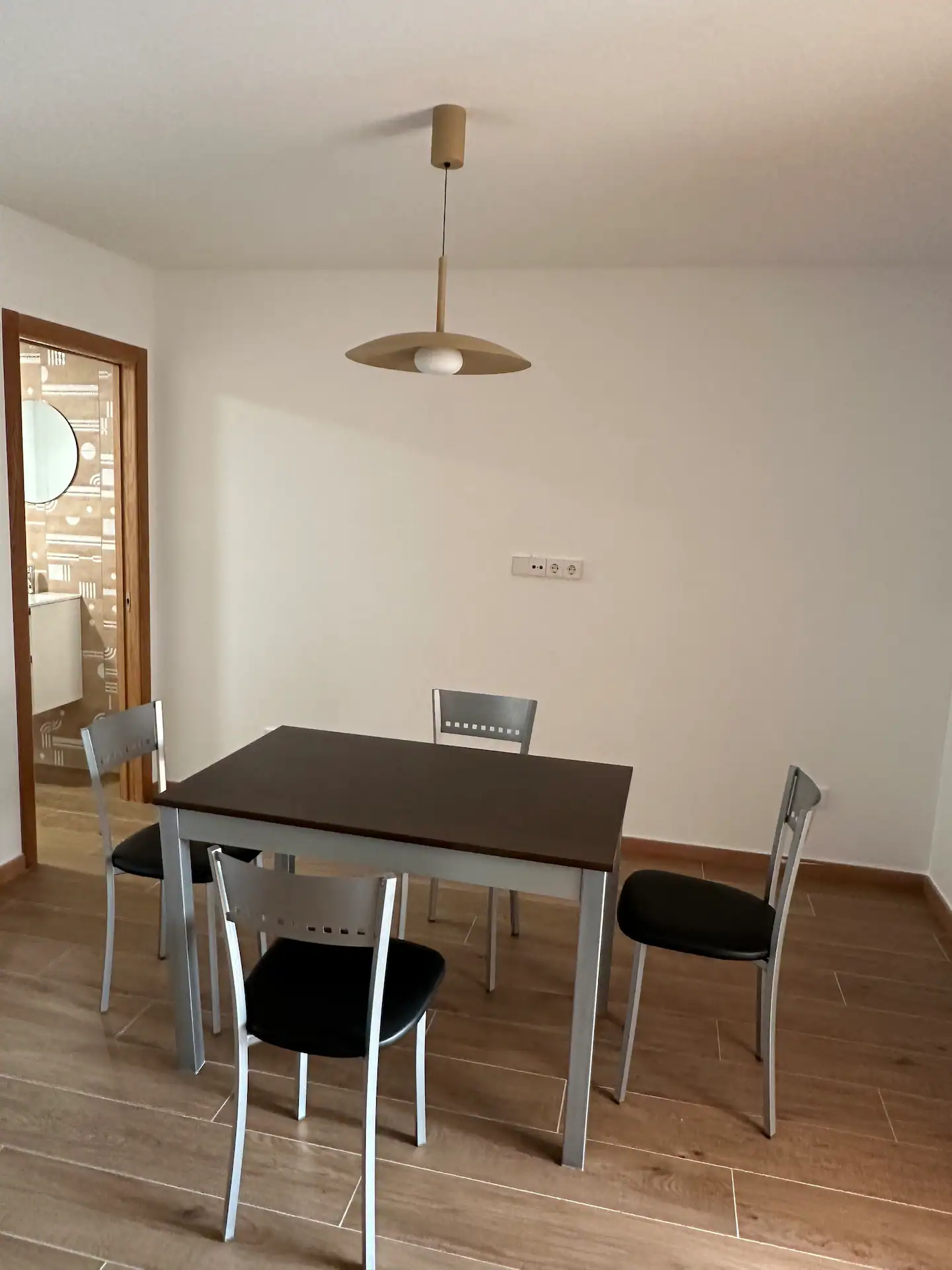 Comedor con mesa rectangular para cuatro, sillas y lámpara colgante de diseño