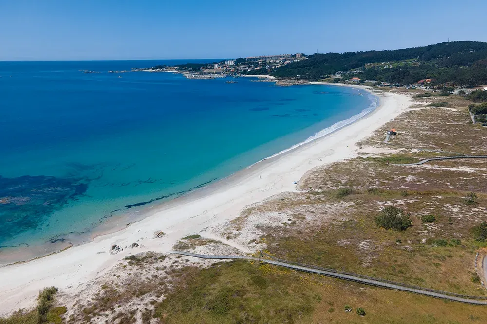 Playa de arena blanca y agua turquesa en la península de O Grove, vista desde el aire